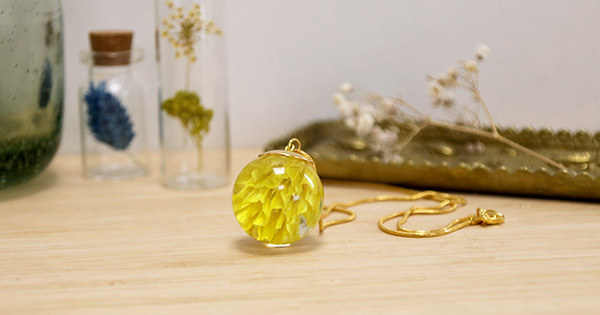 Pendentif boule en résine avec inclusion d'une fleur de phalaris