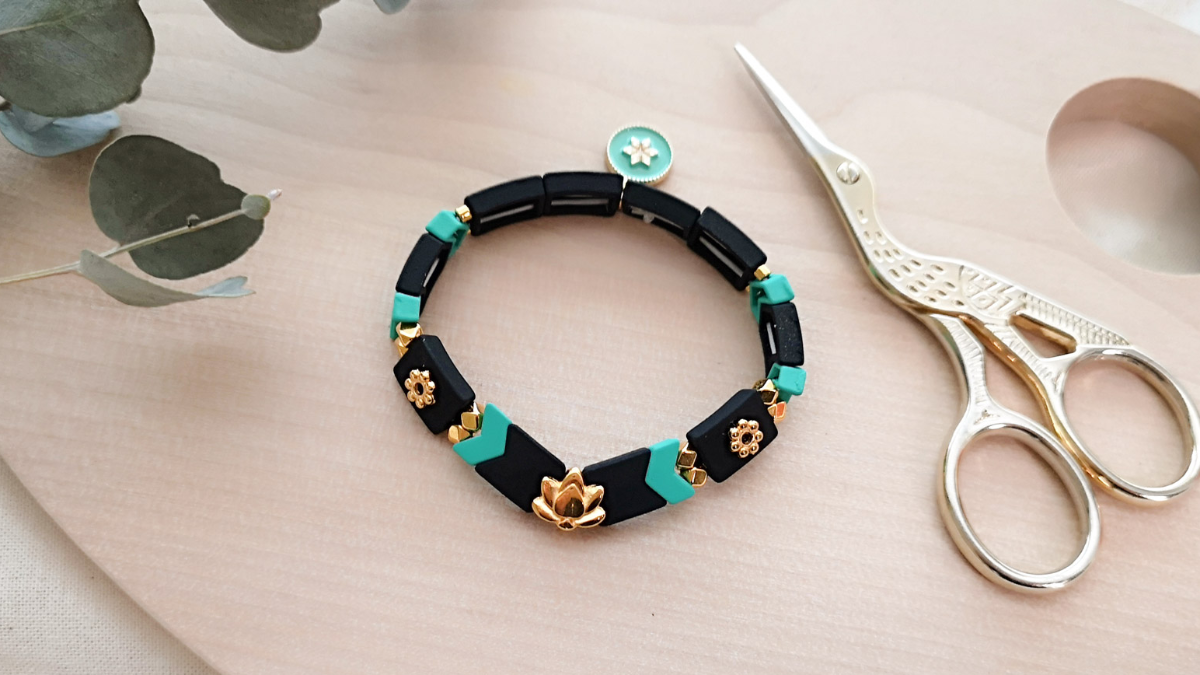 Bracelet élastique perles effet gomme chevrons et intercalaire lotus doré