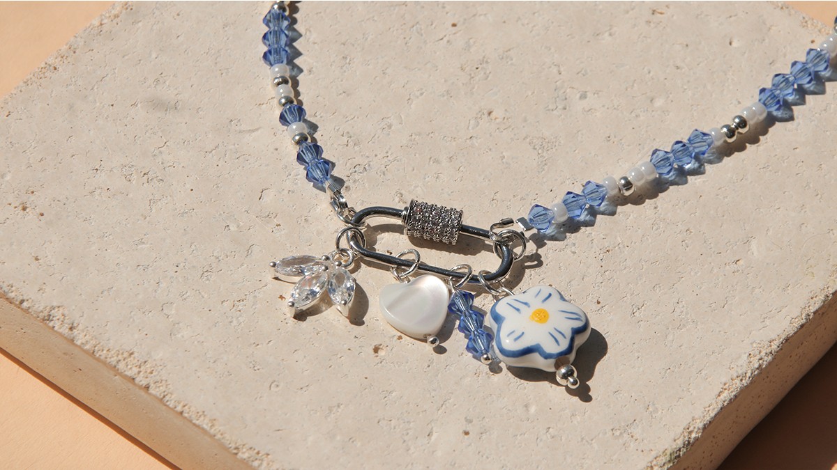 Collier fermoir ovale, toupies bleues et accumulation de breloques