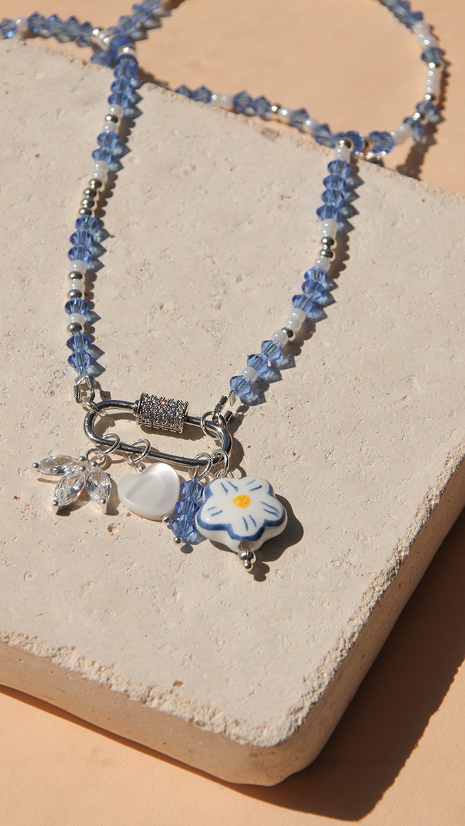 Schéma Collier fermoir ovale, toupies bleues et accumulation de breloques